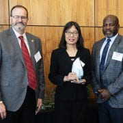 FACULTY AWARD — Yi Liang, center, accepts the John W. White Outstanding Extension State Faculty award from Arkansas Cooperative Extension Service Director Bob Scott, left, and Vice President of Agriculture Deacue Fields. (U of A System Division of Ag photo by Fred Miller)