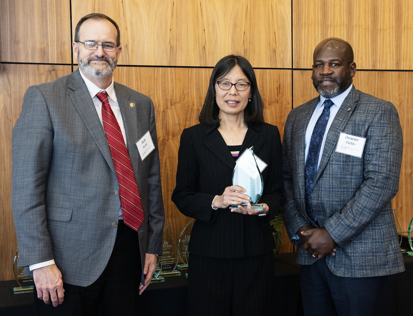 FACULTY AWARD — Yi Liang, center, accepts the John W. White Outstanding Extension State Faculty award from Arkansas Cooperative Extension Service Director Bob Scott, left, and Vice President of Agriculture Deacue Fields. (U of A System Division of Ag photo by Fred Miller)