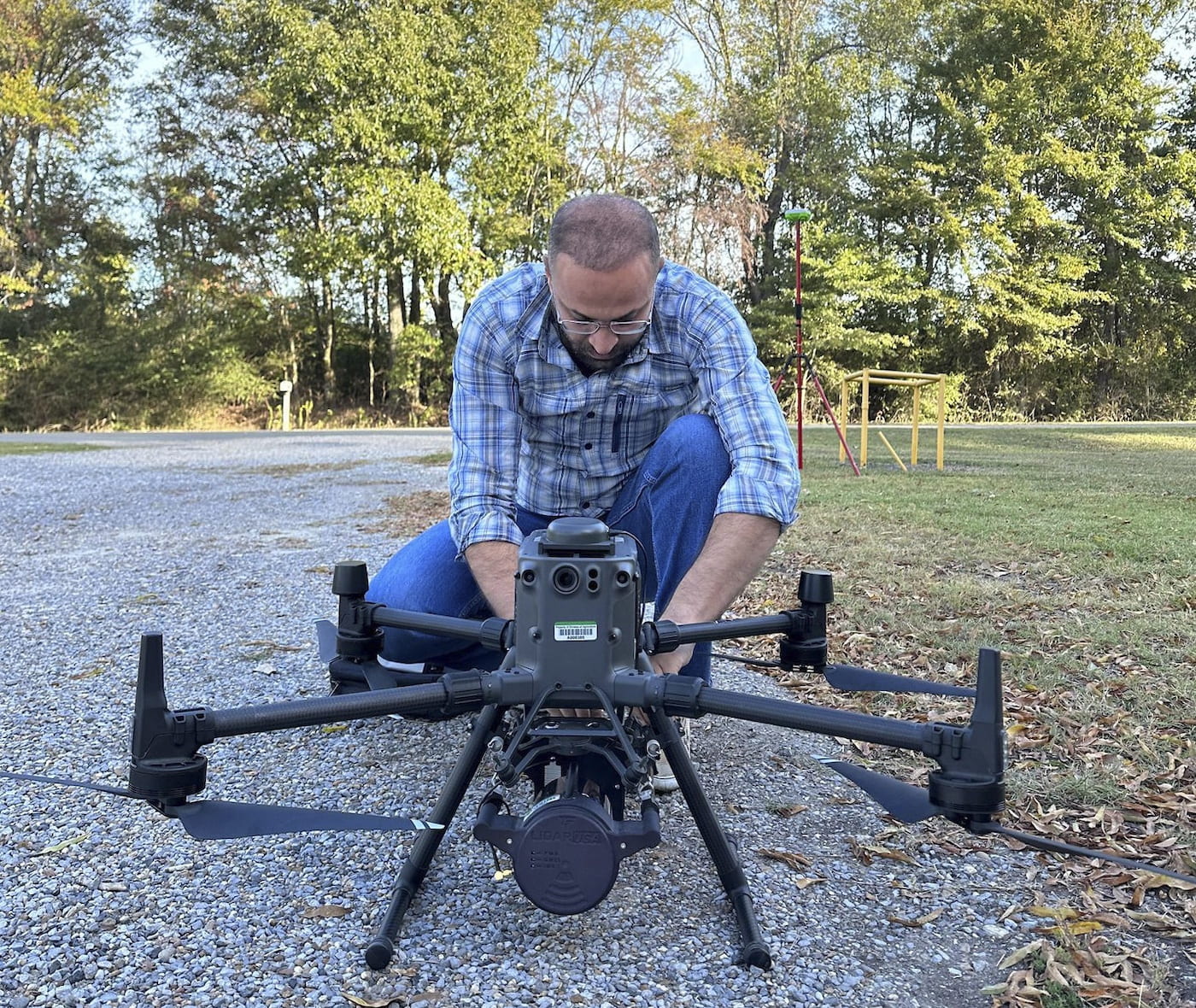 UNMANNED AIRCRAFT — Hamdi Zurqani, remote sensing researcher and assistant professor for the College of Forestry, Agriculture and Natural Resources at University of Arkansas at Monticello, inspects a drone outfitted with a LiDAR, or light detection and ranging, system. (U of A System photo courtesy of Zurqani.)