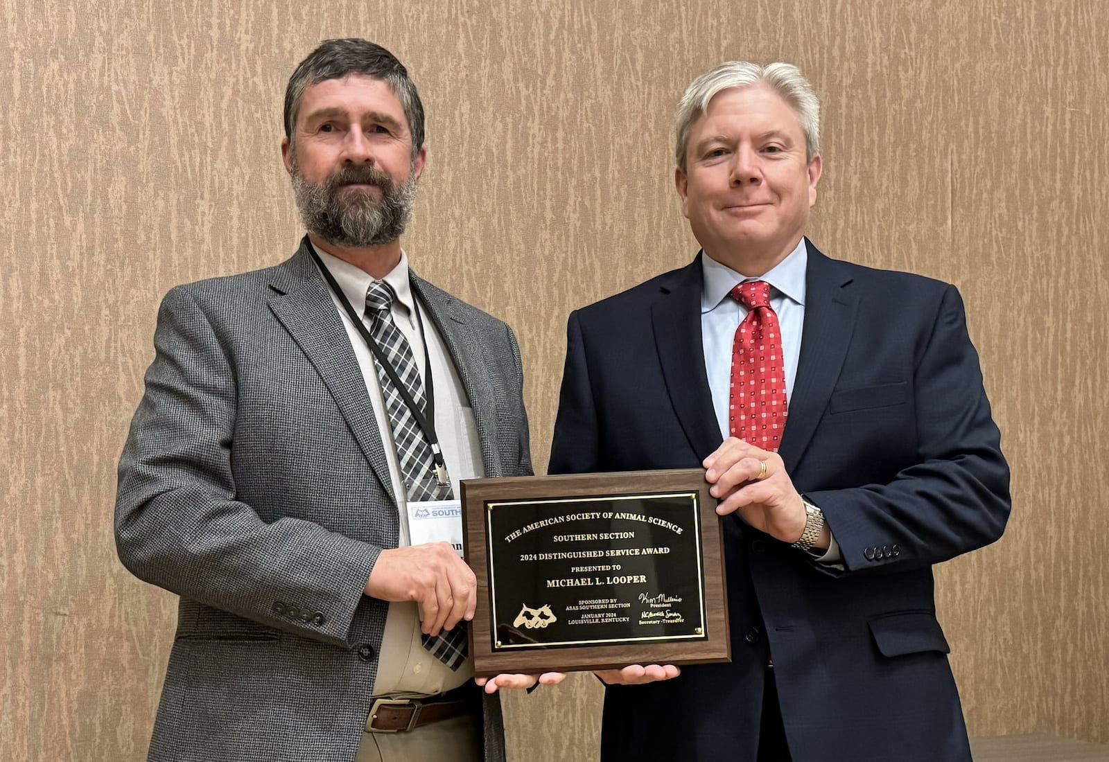 DISTINGUISHED SERVICE — Shane Gadberry, left, director of the Livestock and Forestry Research Station near Batesville, presents a plaque to Mike Looper recognizing him as the American Society of Animal Science Southern Section Distinguished Service Award honoree for 2024. (Photo courtesy of Justin Bartlett)