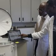 CARBON DIOXIDE SENSORS — Griffiths Atungulu, left, director of the Rice Processing Program, works with Samuel Olaoni, Ph.D. student, on a miniature grain bin to test carbon dioxide sensors for monitoring grain quality. (U of A System Division of Agriculture photo)