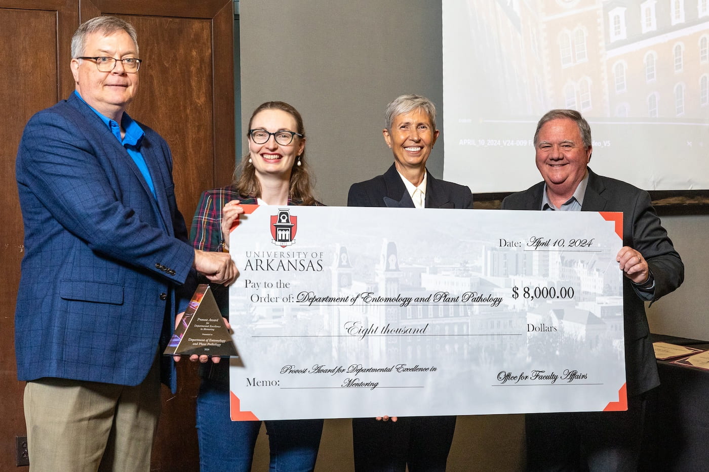 Ken Korth, Fiona Goggin, Anna Zajicek, and Terry Martin, from left to right, are holding a big check, $8,000, for 2024 Provost Award for Departmental Excellence