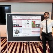 Pouya Sohrabipour, BAEG student, stands next to his research poster titled "Advanced Poultry Automation: Integrating 3D Vision Reconstruction and Mask R-CNN for Efficient Chicken Handling".