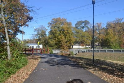 A paved trail leads to a small bridge