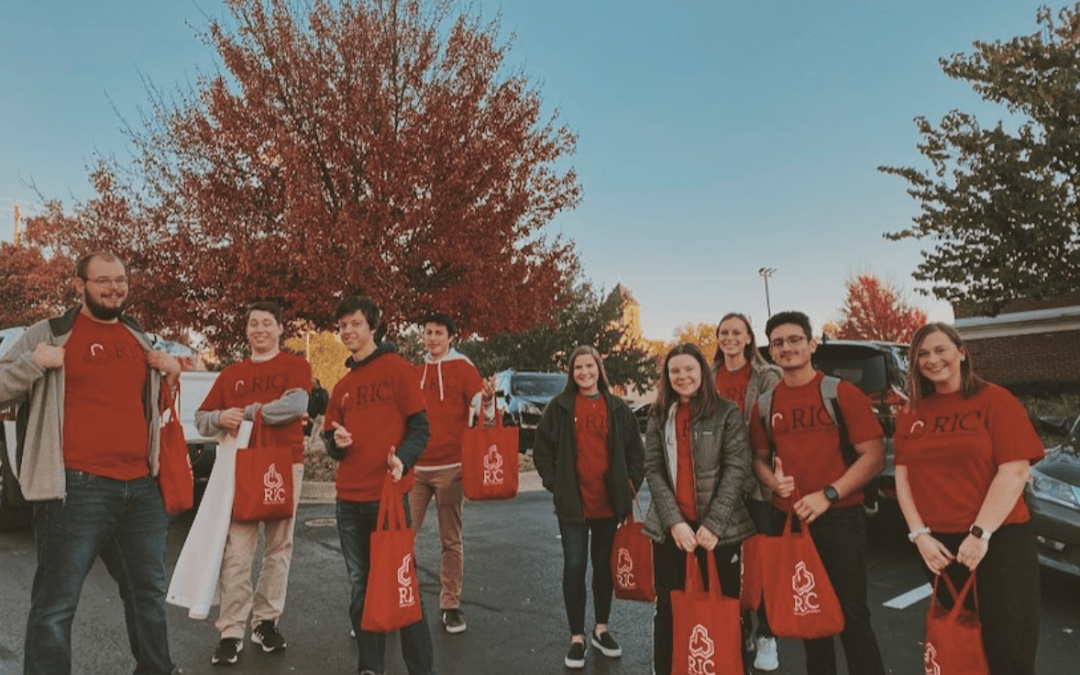 RIC members at a gameday cleanup in the fall--they're wearing red RIC shorts and carrying red RIC totes for picking up trash.
