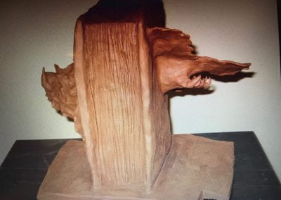 A sculpture that consists of a history book with a Cardinal flying in and a Hog busting out the other side with the base of the sculpture the state of Arkansas.